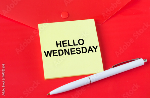 Yellow sticker with text Hello Wednesday on red folder