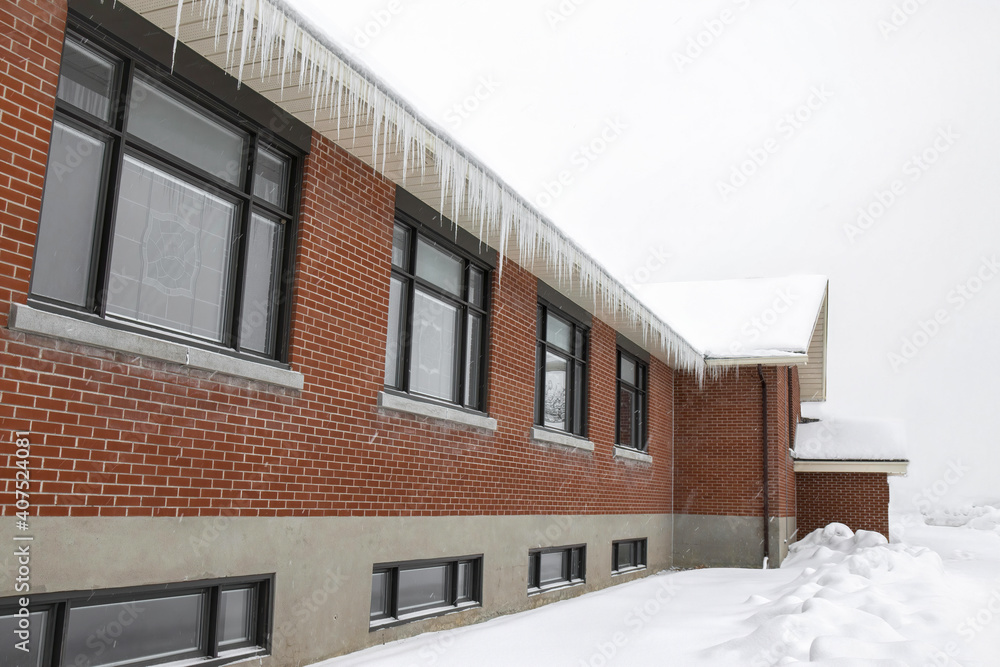 Red brick building in snow with black metal clad windows, icicles nobody Red brick building in snow with black metal clad windows, icicles nobody
