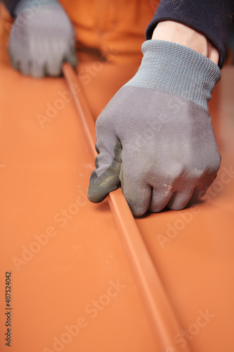 Detail of shaping sheet metal roof components in workroom photo