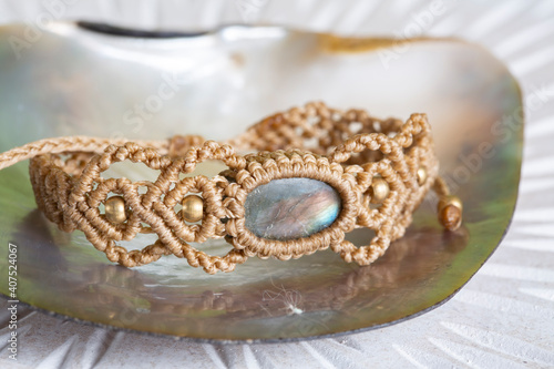 Waxed string made labradorite stone beige bracelet on natural neutral background