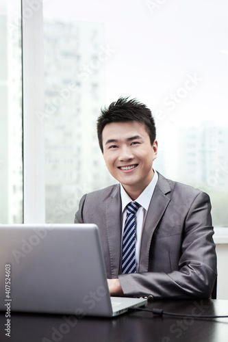 Portrait of Businessman using laptop in office © eastfenceimage