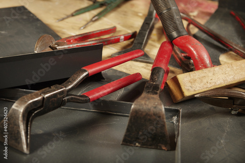 Detail of pliers and trimming tools of roof plumbers on table photo