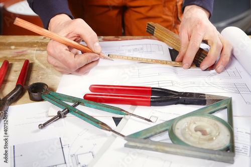 Detail of tools, folding meter, inclinometer and drawing on table photo