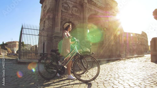Wallpaper Mural Three happy young women friends tourists walking with bikes at Colosseum in Rome, Italy at sunrise. Torontodigital.ca