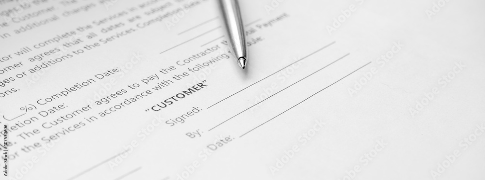 Close-up of a silver pen on docunent contract. Legal contract signing. Buy sell real estate contract agreement. Customer sign on document paper with silver pen