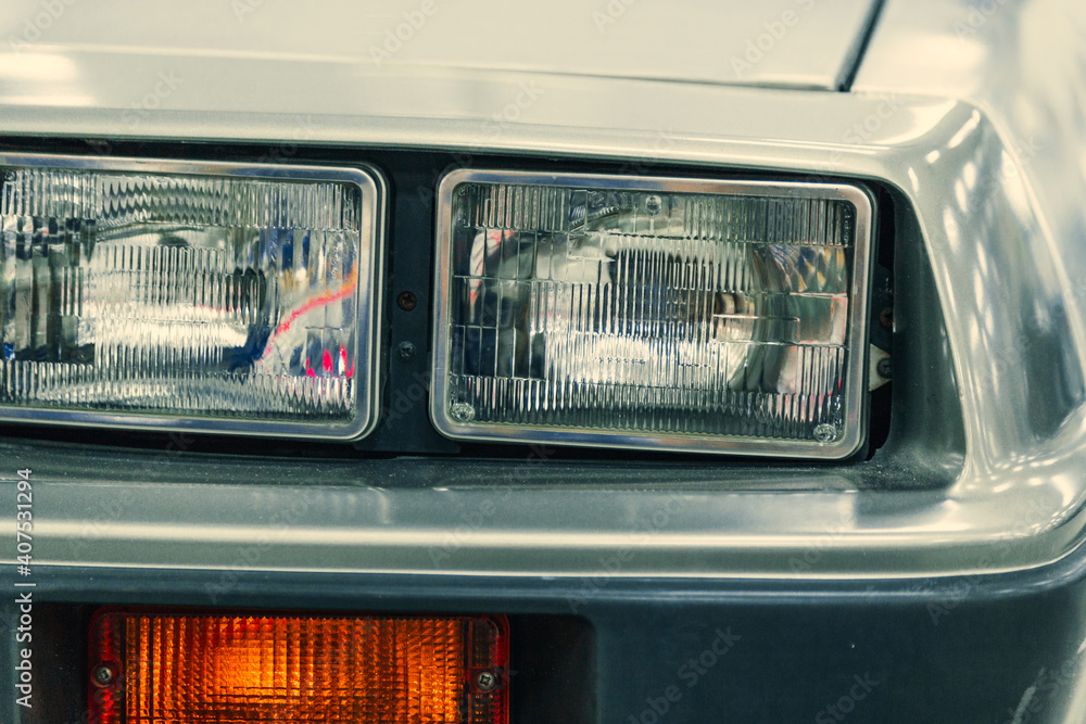 close-up halogen headlight of white retro car.