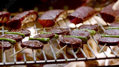 Slow motion.Turkish street vendor is cooking barbecue sausage.Turkish Sucuk. Barbecue beef sausages (Turkish sucuk) are cooking. photo