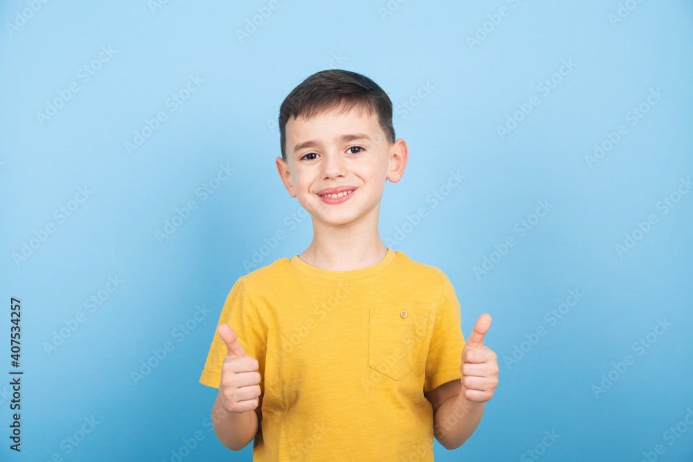 Little boy is showing thumb up gesture using both hands. Optimistic attitude
