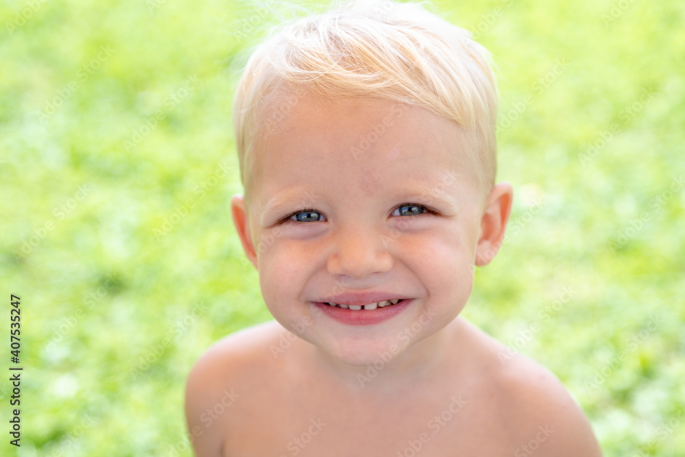 Closeup face of cute smiling spring child. Kid emotions concept. Portrait of young laughing boy outdoor. Closeup face of cute smiling spring child. Kid emotions concept. Portrait of young laughing boy outdoor.