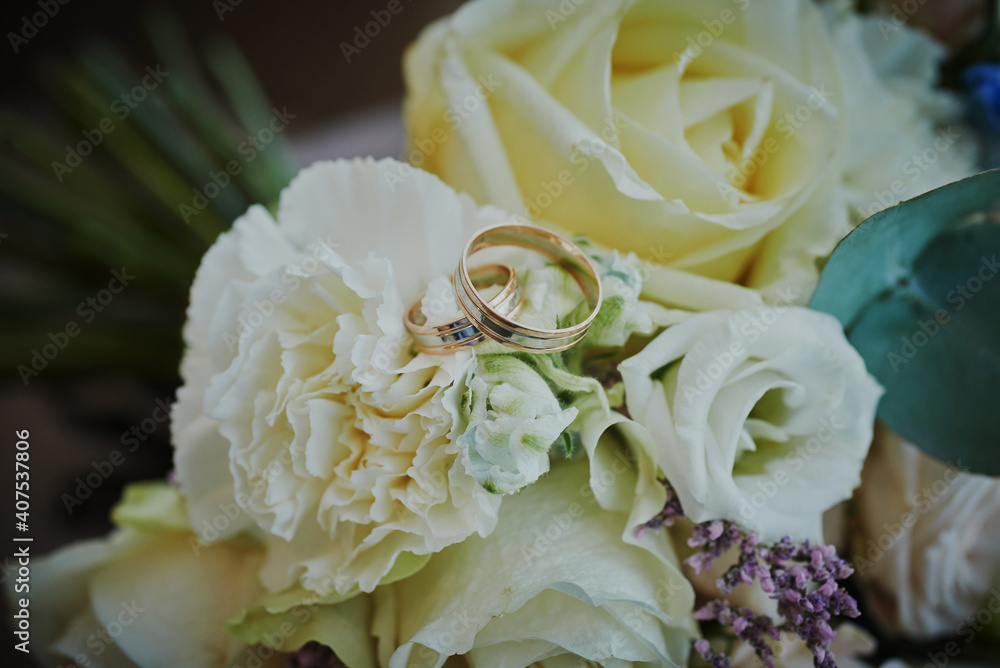 gold rings and a beautiful bridal bouquet of roses on the background. details, wedding traditions. close-up, macro gold rings and a beautiful bridal bouquet of roses on the background. details, wedding traditions. close-up, macro