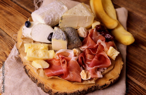 different types of cheeses with delicacy meat wooden surface selective focus. cheese platter.
