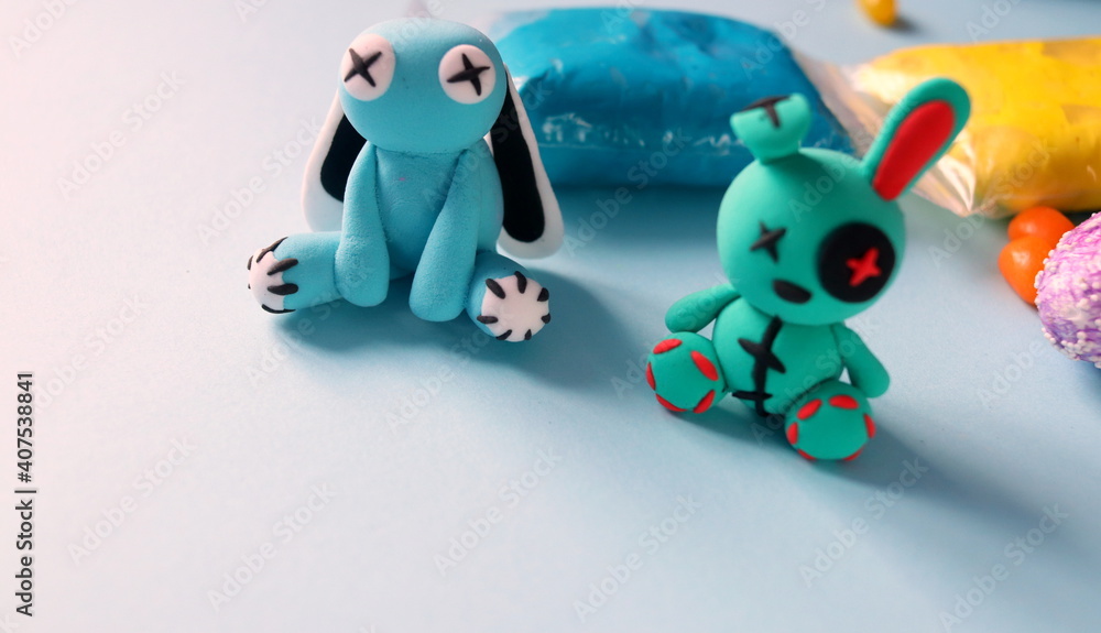 plasticine rabbit of bright color made by children's hands close-up selective focus. children's crafts from plasticine. plasticine rabbit of bright color made by children's hands close-up selective focus. children's crafts from plasticine.