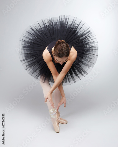 attractive ballerina poses gracefully in the studio on a white background