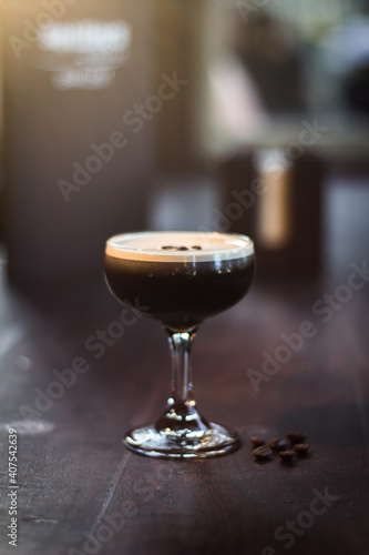 Espresso Martini cocktail drink beverage with coffee beans on a wooden table
