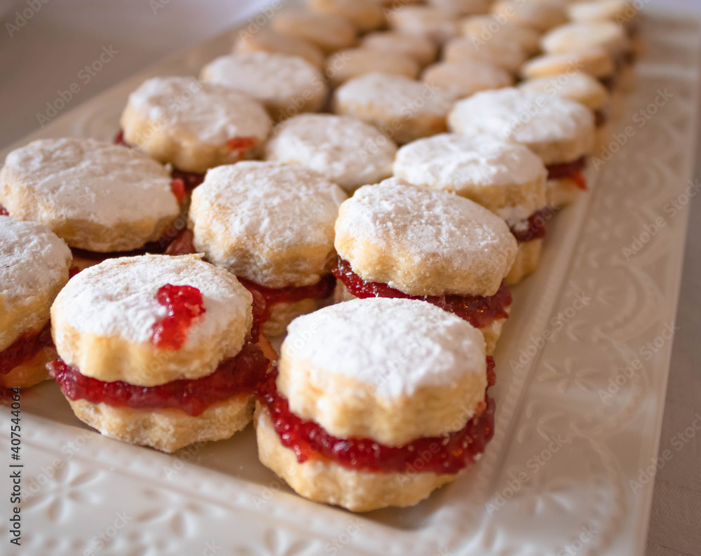  Close up of small vanilla cookies (vanilice), traditional Serbian jam sandwich cookies  covered by powdered sugar