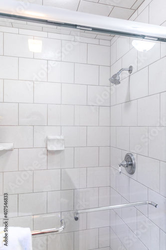 Renovated white subway tile bathroom shower with glass door