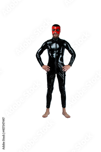 Adult kinky man dressed in fetish latex rubber costume with black red pvc mask isolated on white background. Caucasian man dressed in fashionable latex rubber fetish clothes. fetish man in black mask