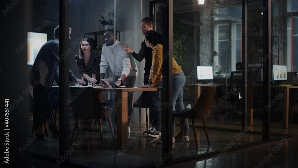 Young Creative Team Meeting with Business Partners in Conference Room Behind Glass Walls in Agency. Colleagues Sit Behind Conference Table and Discuss Business Opportunities, Growth and Development. Young Creative Team Meeting with Business Partners in Conference Room Behind Glass Walls in Agency. Colleagues Sit Behind Conference Table and Discuss Business Opportunities, Growth and Development.