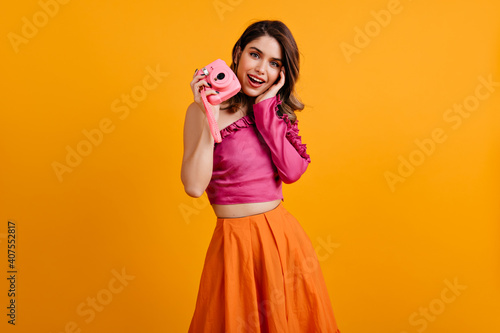 Refined girl enjoying her hobby. Amazing brunette lady holding camera.