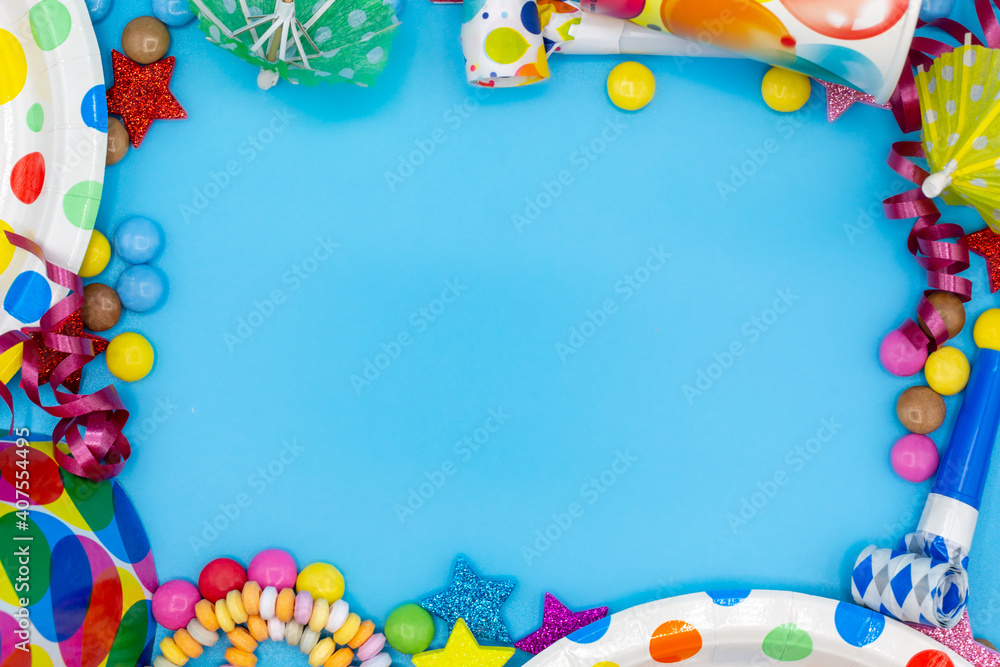 Frame of items for children's birthday or party with smarties and air snakes for invitations with copy space