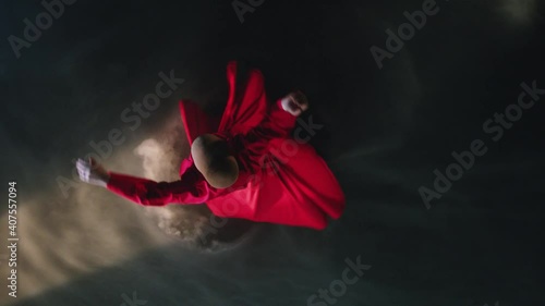 Whirling dervish with red clothes in a black background. Mevlevi Dervish slow motion. photo