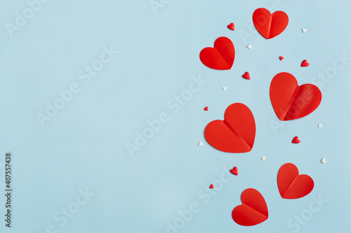 Valentine s Day background February 14th. Confetti  red hearts of paper on pastel blue background. Valentines day concept. Flat lay  top view  copy space.
