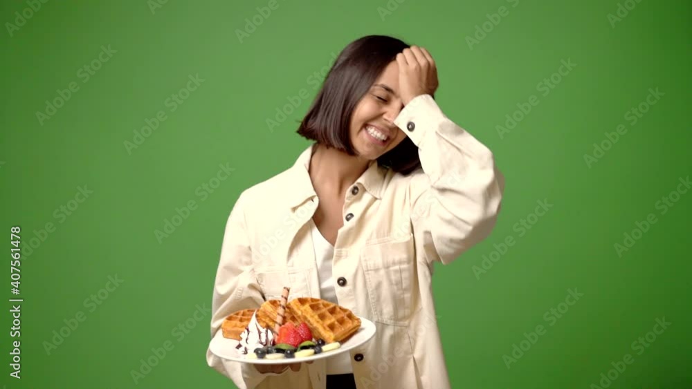 woman holding waffles intending to realizes the solution while lifting a finger up woman holding waffles intending to realizes the solution while lifting a finger up