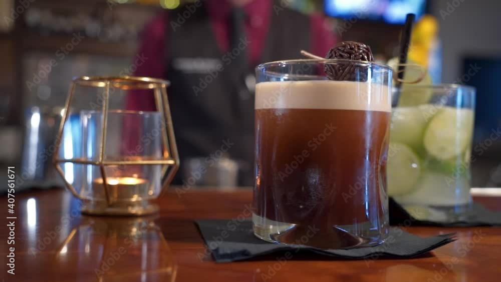 Two beverages on bar margarita and chocolate coffee cocktail with bartender in background, slider close up 4K Two beverages on bar margarita and chocolate coffee cocktail with bartender in background, slider close up 4K