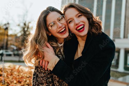 Foto Blithesome female friends laughing in autumn day