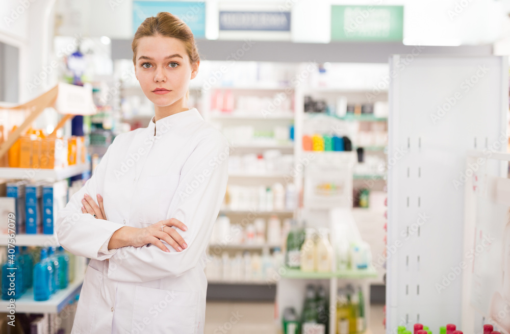 Portrait of young positive female pharmacist in modern drugstore. High quality photo