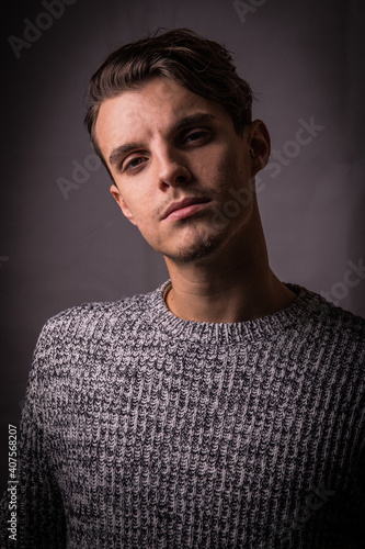 Beautiful model dressed in a winter sweater, isolated on dark background 