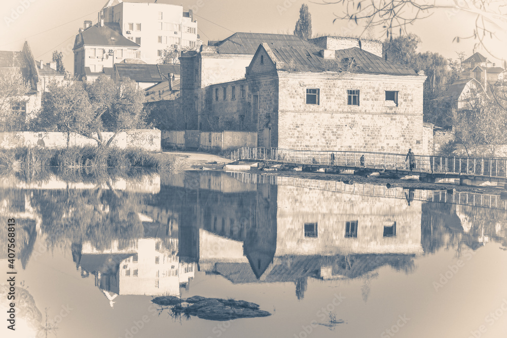 old brick building and river with smooth surface old brick building and river with smooth surface