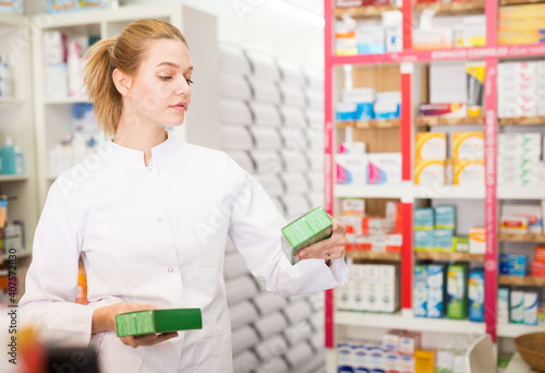 Young friendly female pharmacist suggesting useful tablets in pharmacy. High quality photo