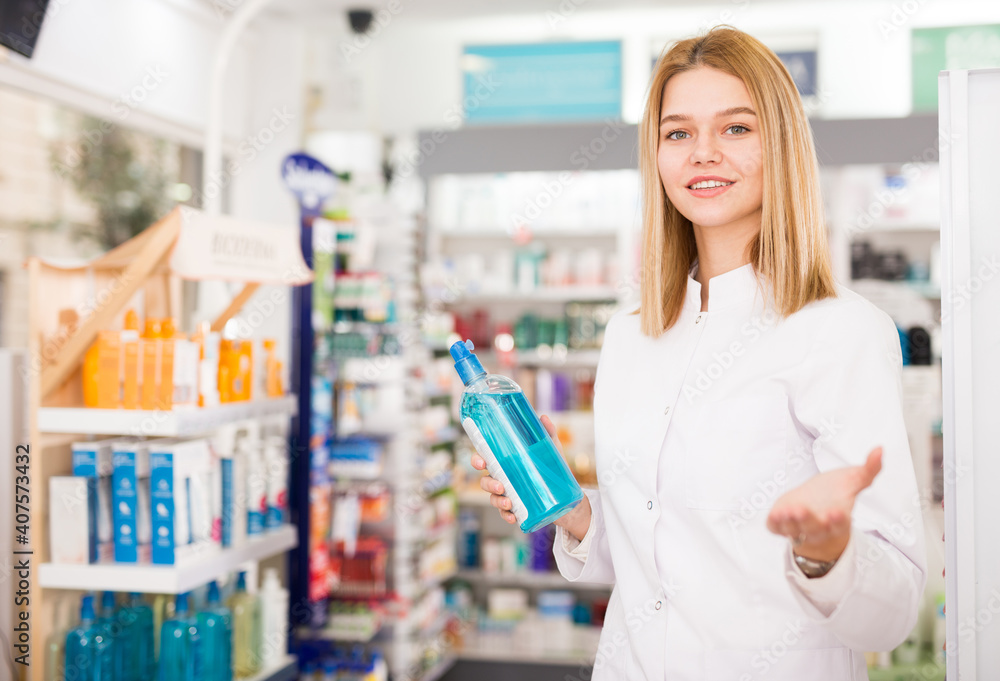 Smiling young pharmacist ready to assist in choosing at counter in pharmacy. High quality photo