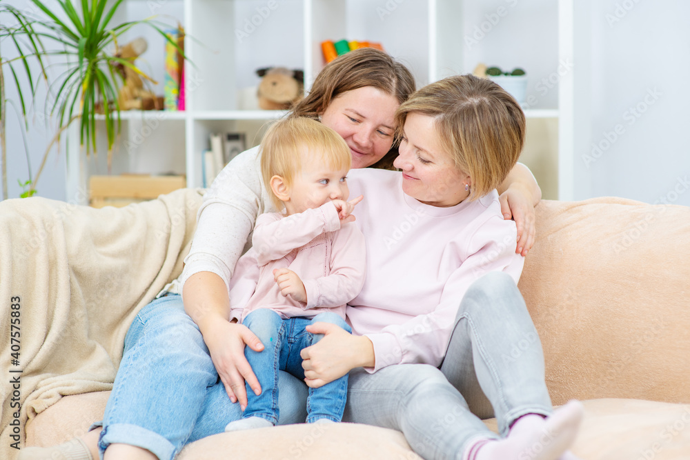 Happy daughter and smiling gay mothers in family home. Gay lesbian couple at home. Lesbian couple concept Happy daughter and smiling gay mothers in family home. Gay lesbian couple at home. Lesbian couple concept