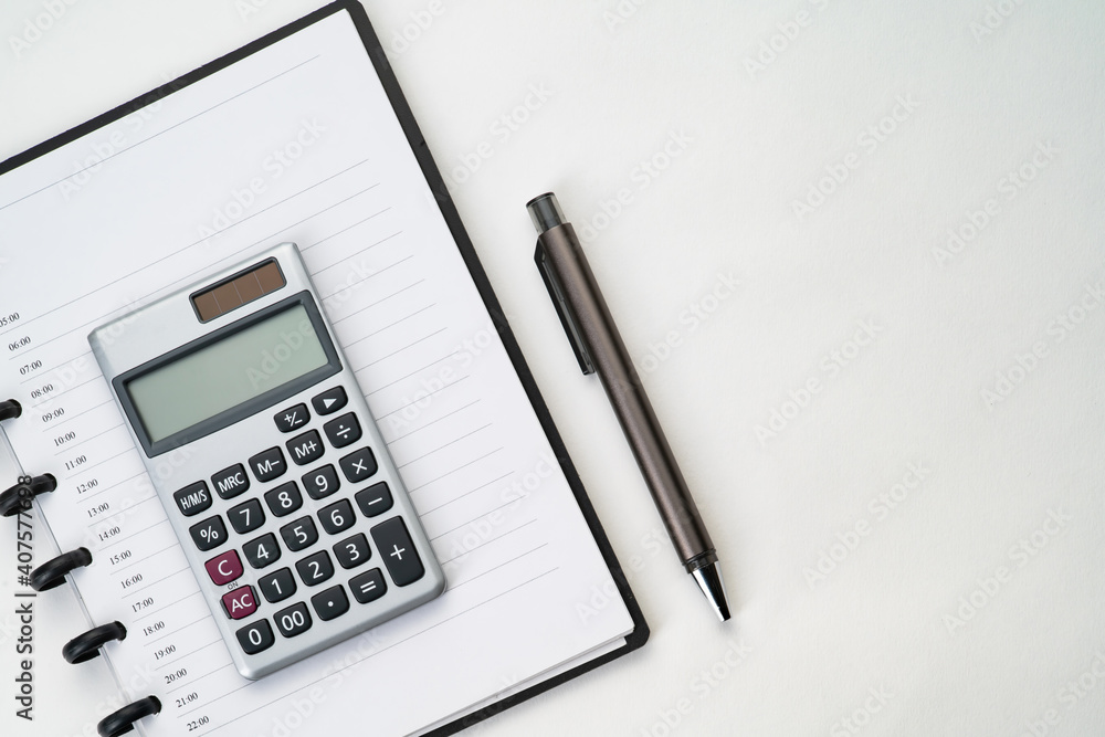 Top view of notebook with pen and calculator with white isolated background Top view of notebook with pen and calculator with white isolated background