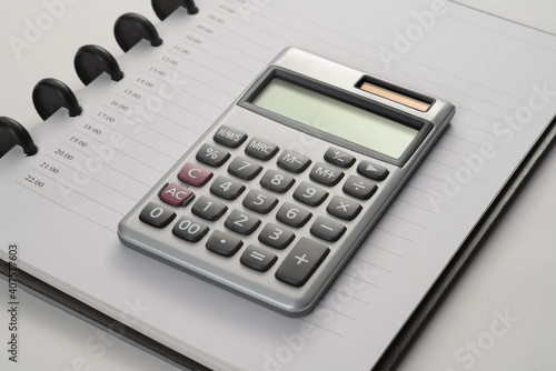 close up of notebook  calculator on white flat surface © naya