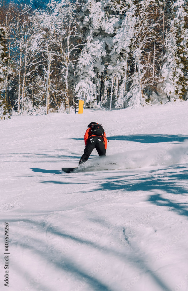 snowboarder in red jacket going down a snowy slope snowboarder in red jacket going down a snowy slope