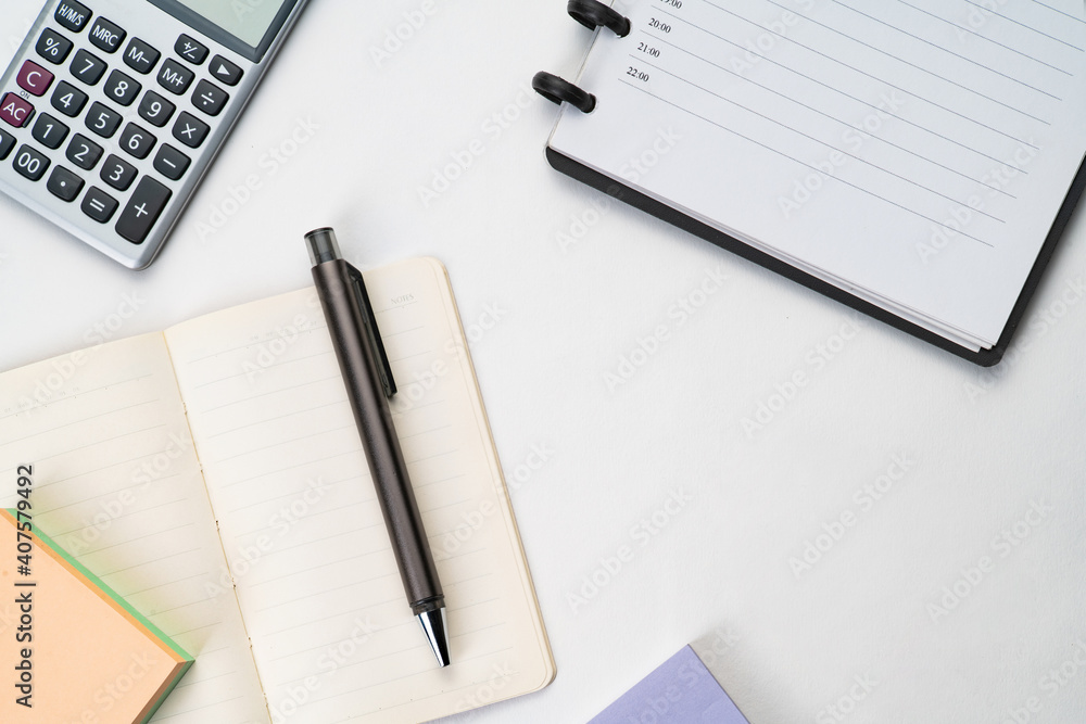 Top view of notebook with pen, sticky note and calculator with white isolated background Top view of notebook with pen, sticky note and calculator with white isolated background