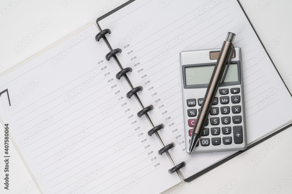 Top view of notebook with pen and calculator with white isolated background Top view of notebook with pen and calculator with white isolated background