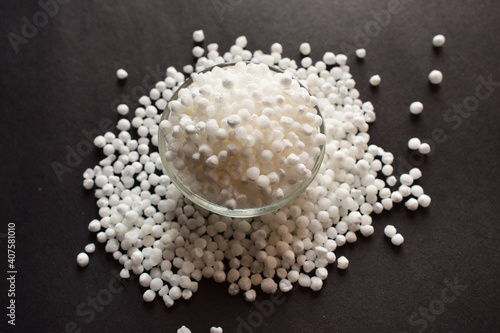 Pearls or white sago seeds balls in a Open Transparent Glass Bowl On isolated Black Background