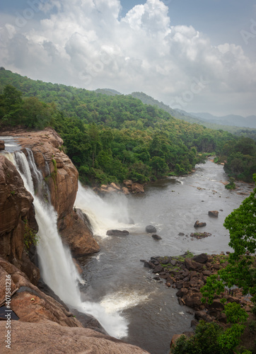 waterfall with cloudy sky and green forests of western ghat range