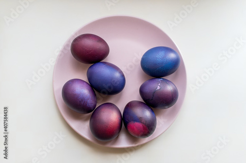 Painted blue and purple Easter eggs on a textured background. Easter eggs on a plate.