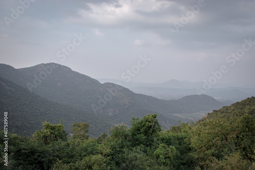 Mountain range with green forests and blue sky