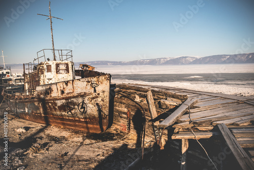 The rusty old ship cemetery stands in the ice of a frozen lake