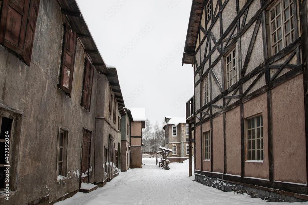 An old street with abandoned houses. Snowy cloudy day. Nobody. Winter abandoned village.