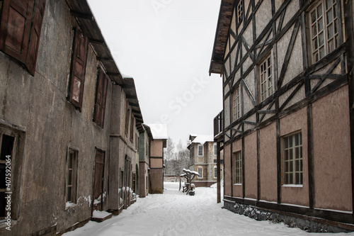 An old street with abandoned houses. Snowy cloudy day. Nobody. Winter abandoned village. © Kooper