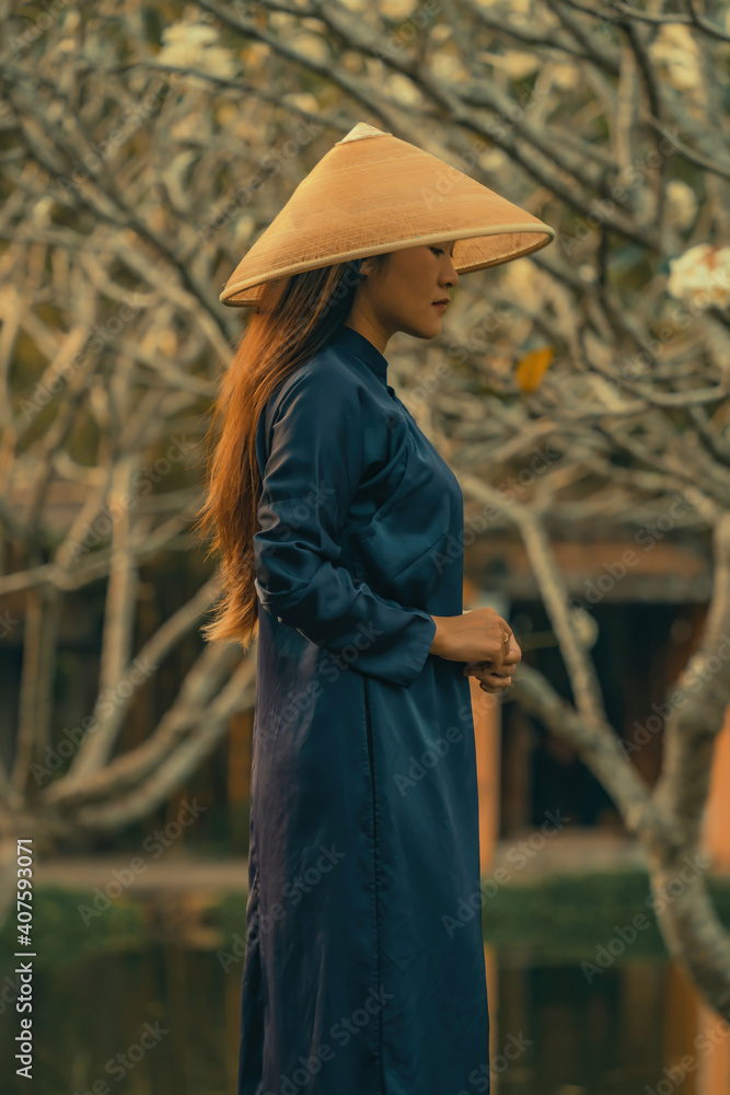 Fototapeta premium Beautiful Vietnam girl from Hue city, Vietnam who wearing Ao dai. Ao dai is famous traditional custume for woman in Vietnam. Vintage style,travel and relaxing concept.