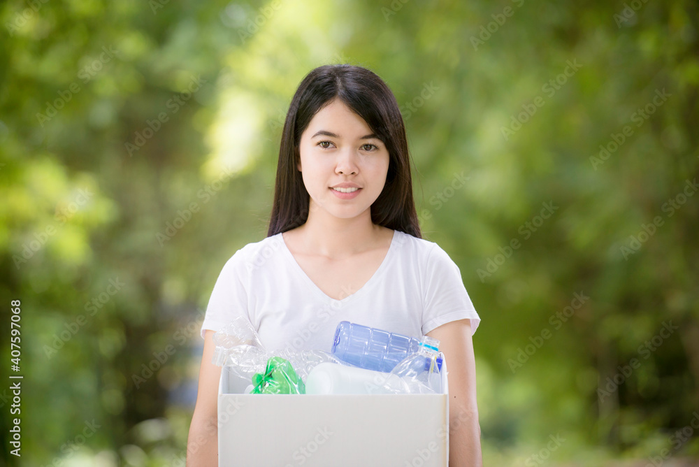 Asian Young woman hand picking up garbage plastic for cleaning at park.Environmental conservation. Asian Young woman hand picking up garbage plastic for cleaning at park.Environmental conservation.