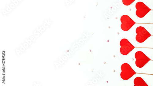 paper red hearts on a wooden skewer with round beads on a white background with a place for text, Valentine's Day celebration concept